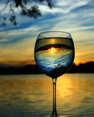 wine glass with mountain and lake sunset